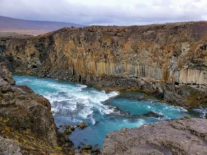 Turquoise river rushing through basalt canyon near Aldeyjarfoss, Iceland.